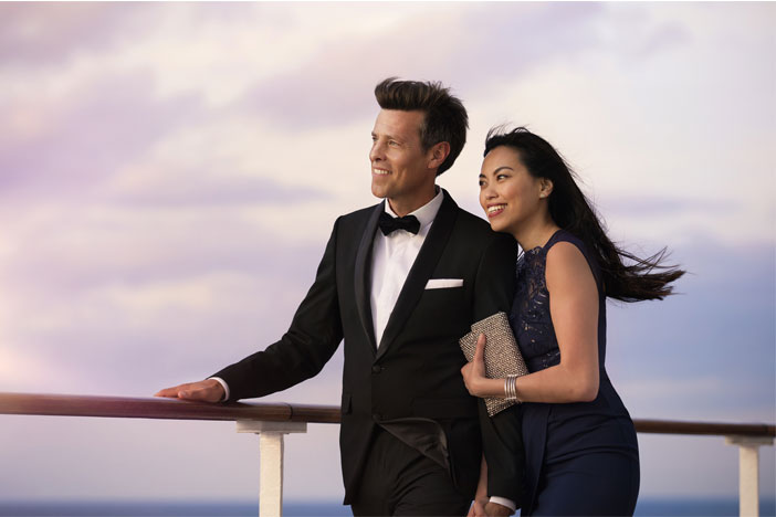Formally dressed man and woman watching the ship sail