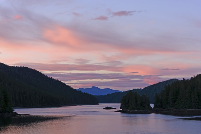 a view of the Inside Passage in Alaska from the water at sunset