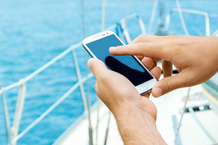 man-holding-mobile-phone-on-cruise-ship