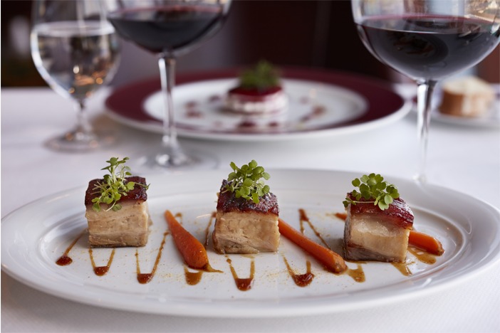 Cake in a white plate and half-filled wine glasses
