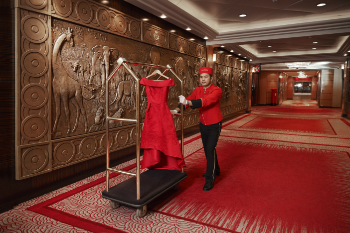 bellhop transporting a red evening gown
